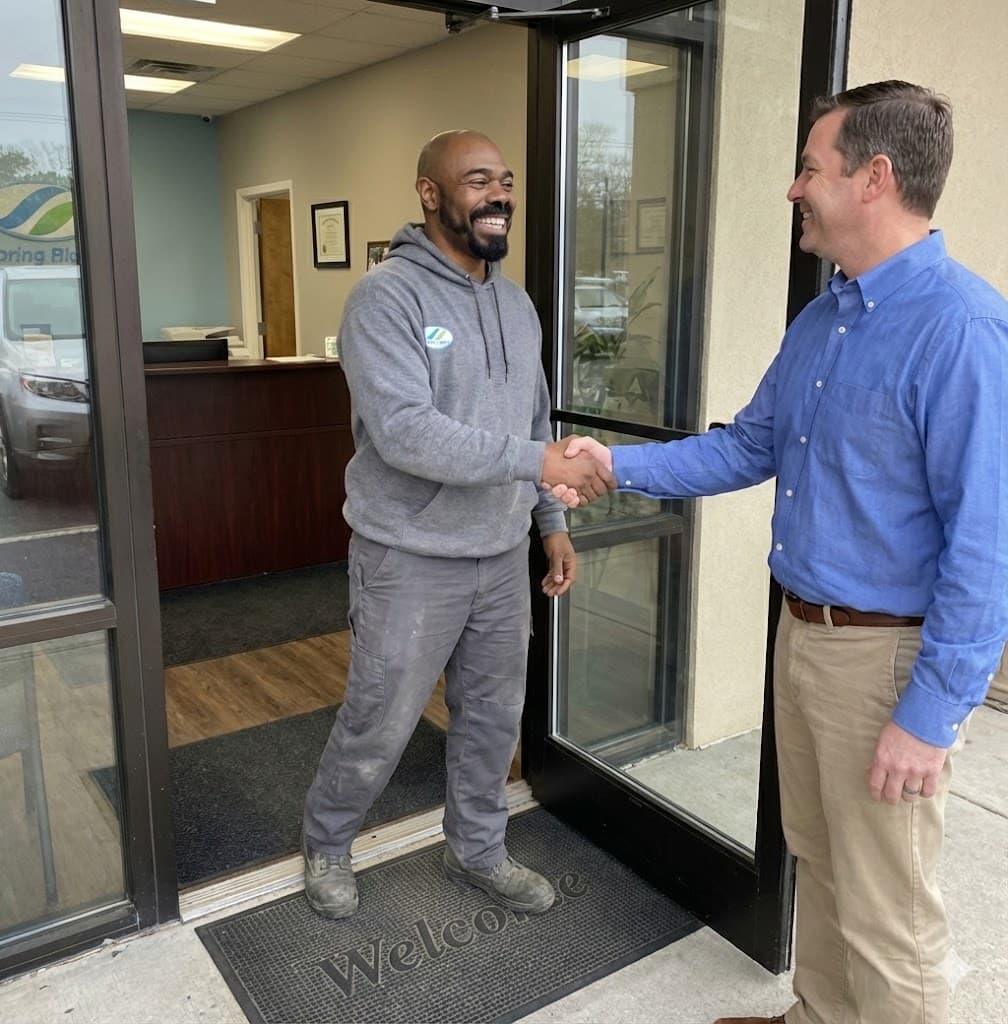 Owner James Green shaking hands with a customer at the Totally Clean office